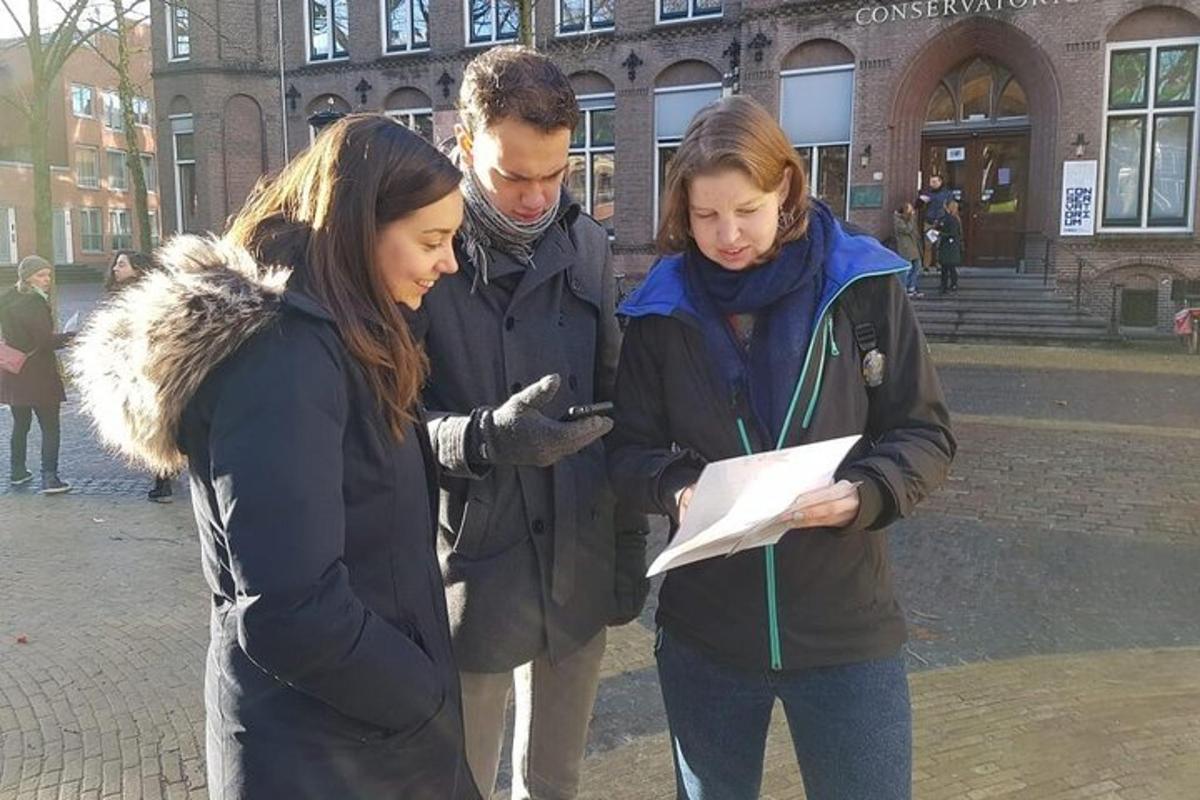 skupina treh ljudi, ki gledajo v mobilni telefon