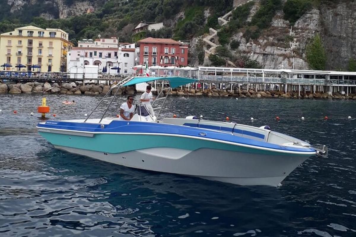 two people in a blue and white boat in the water