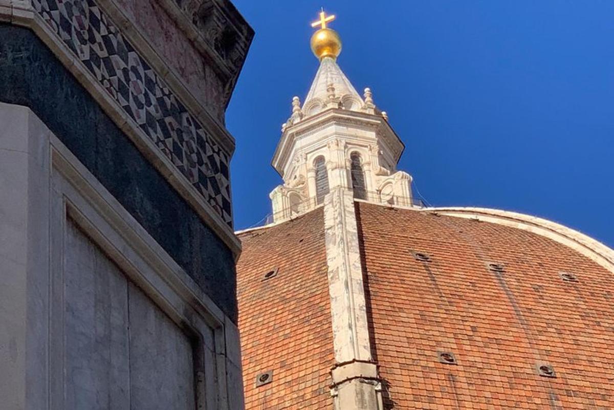 uma torre no topo de um prédio de tijolos com uma cruz dourada