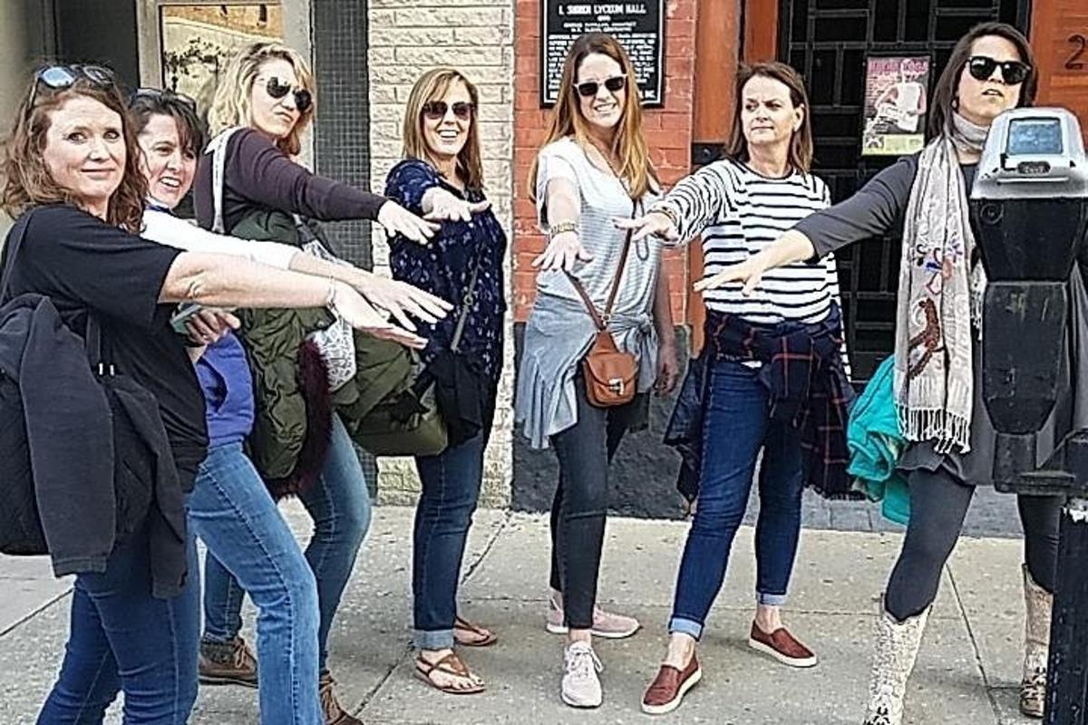 egy csoport nő áll egy parkolóóra mellett