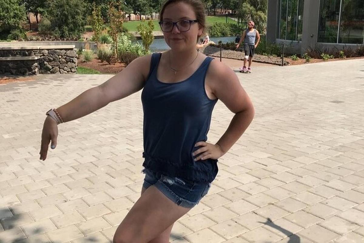 una donna con una canottiera blu e pantaloncini
