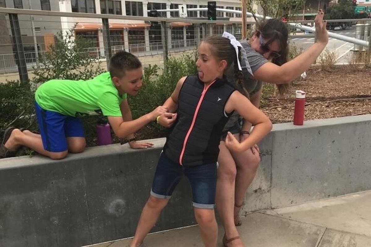 ein Junge und ein Mädchen sitzen auf einer Stützmauer
