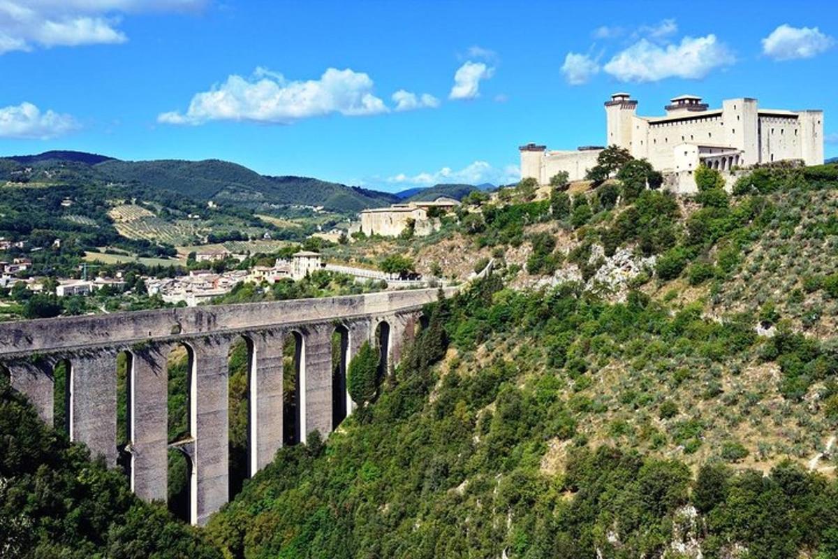un pont sur une colline avec un château en arrière-plan