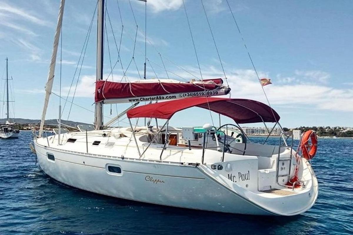 sebuah perahu layar putih dengan kanopi merah di atas air
