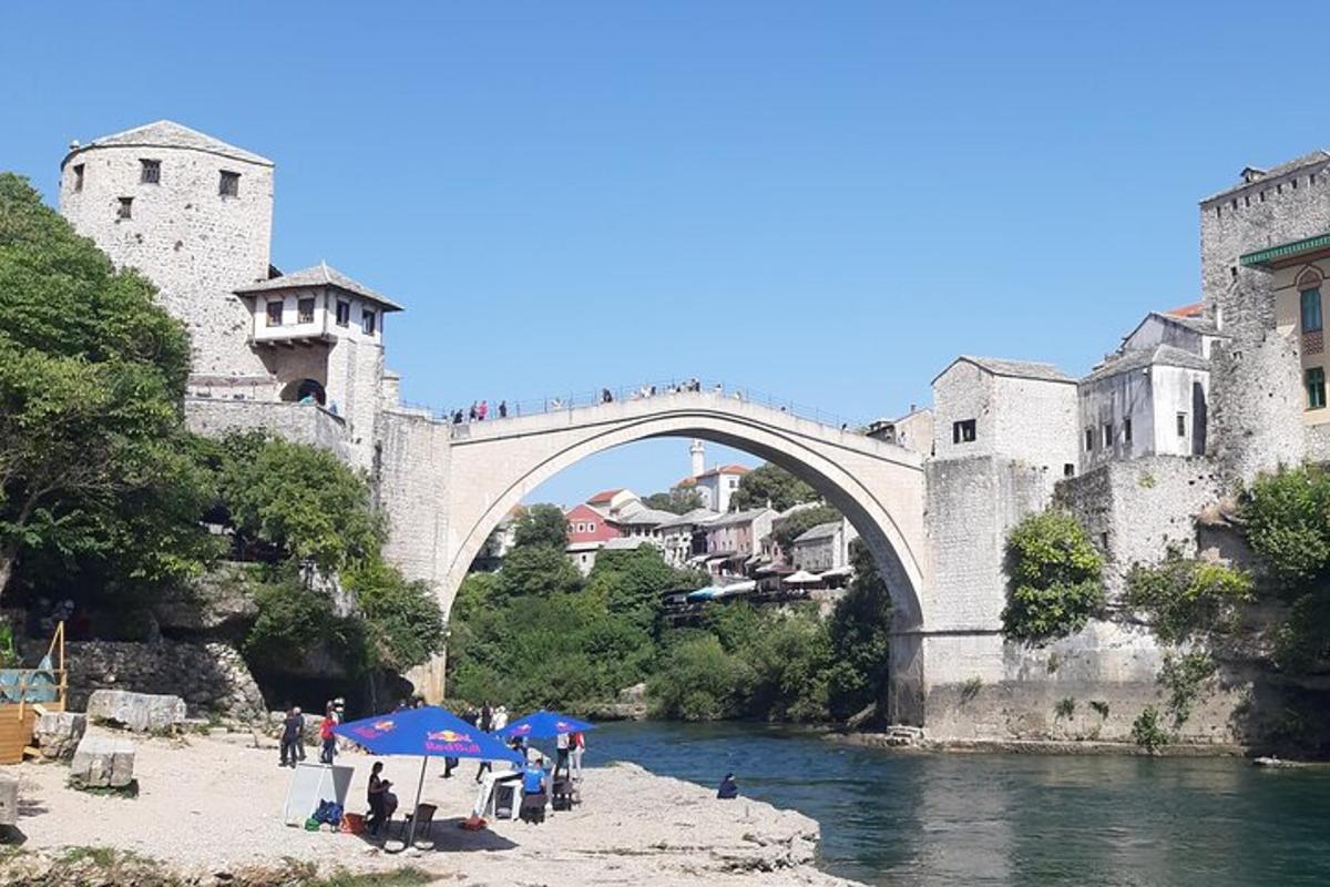 most čez reko z ljudmi, ki sedijo pod senčniki