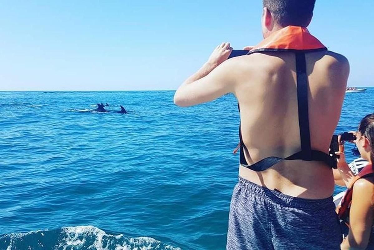 maður í bakpoka stendur í sjónum