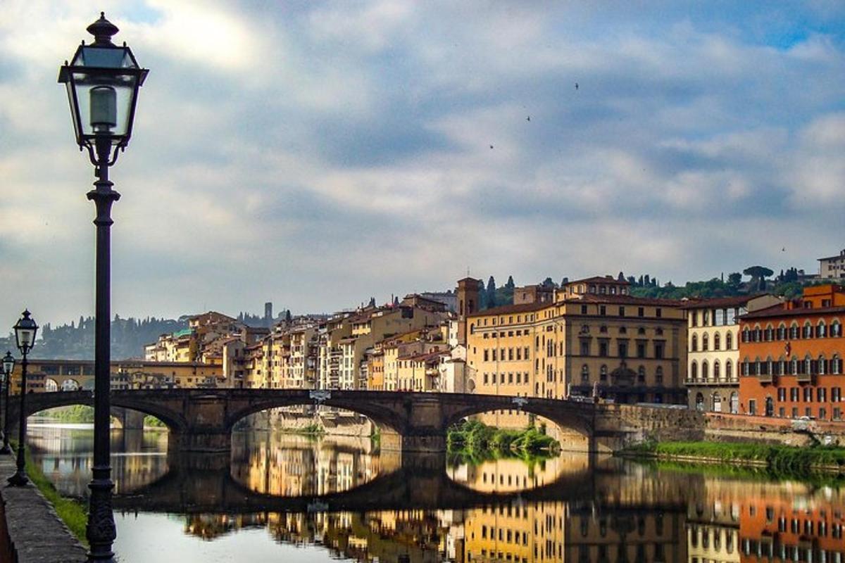 uma ponte sobre um rio com edifícios e um poste de luz