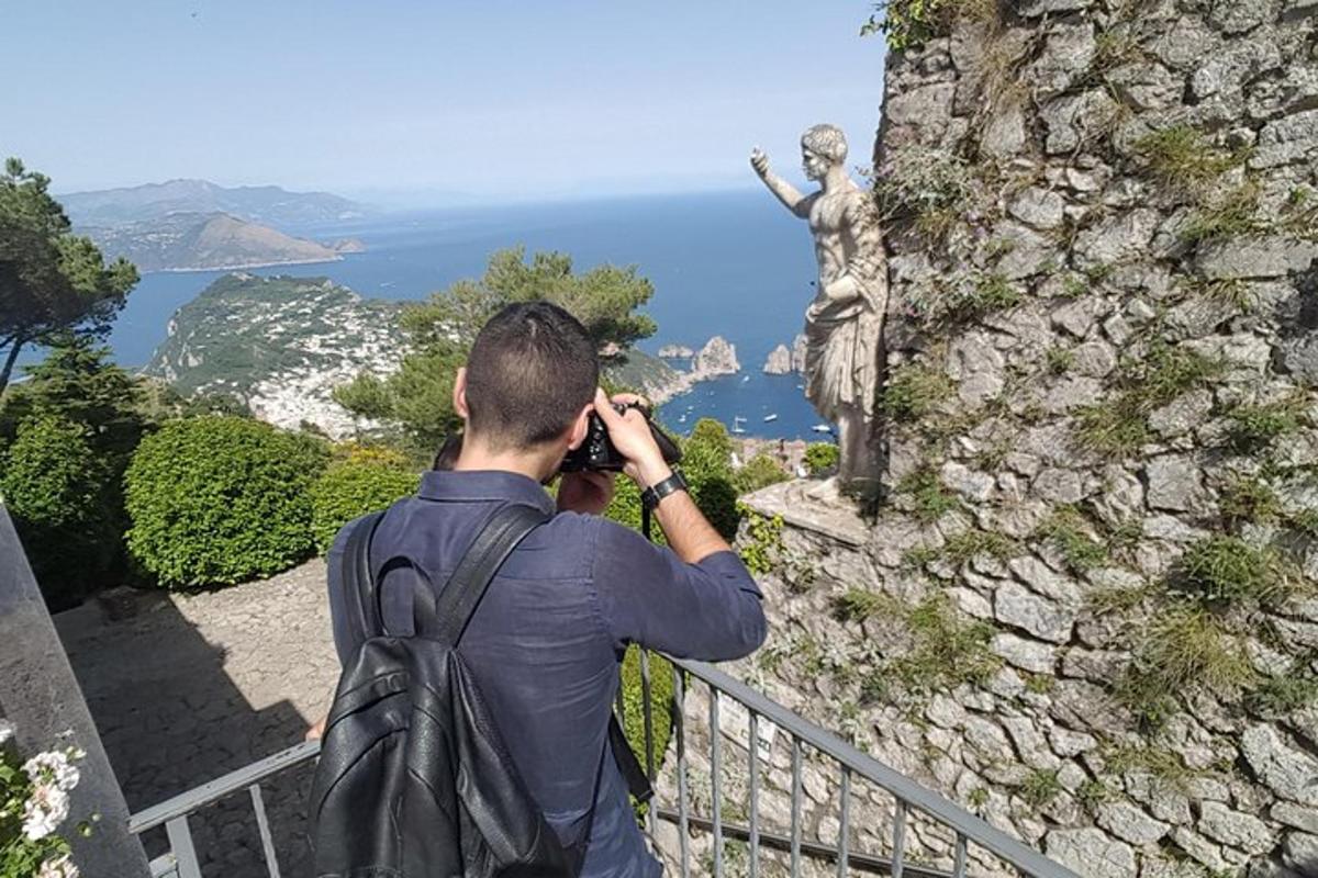 bir heykelin fotoğrafını çeken bir adam