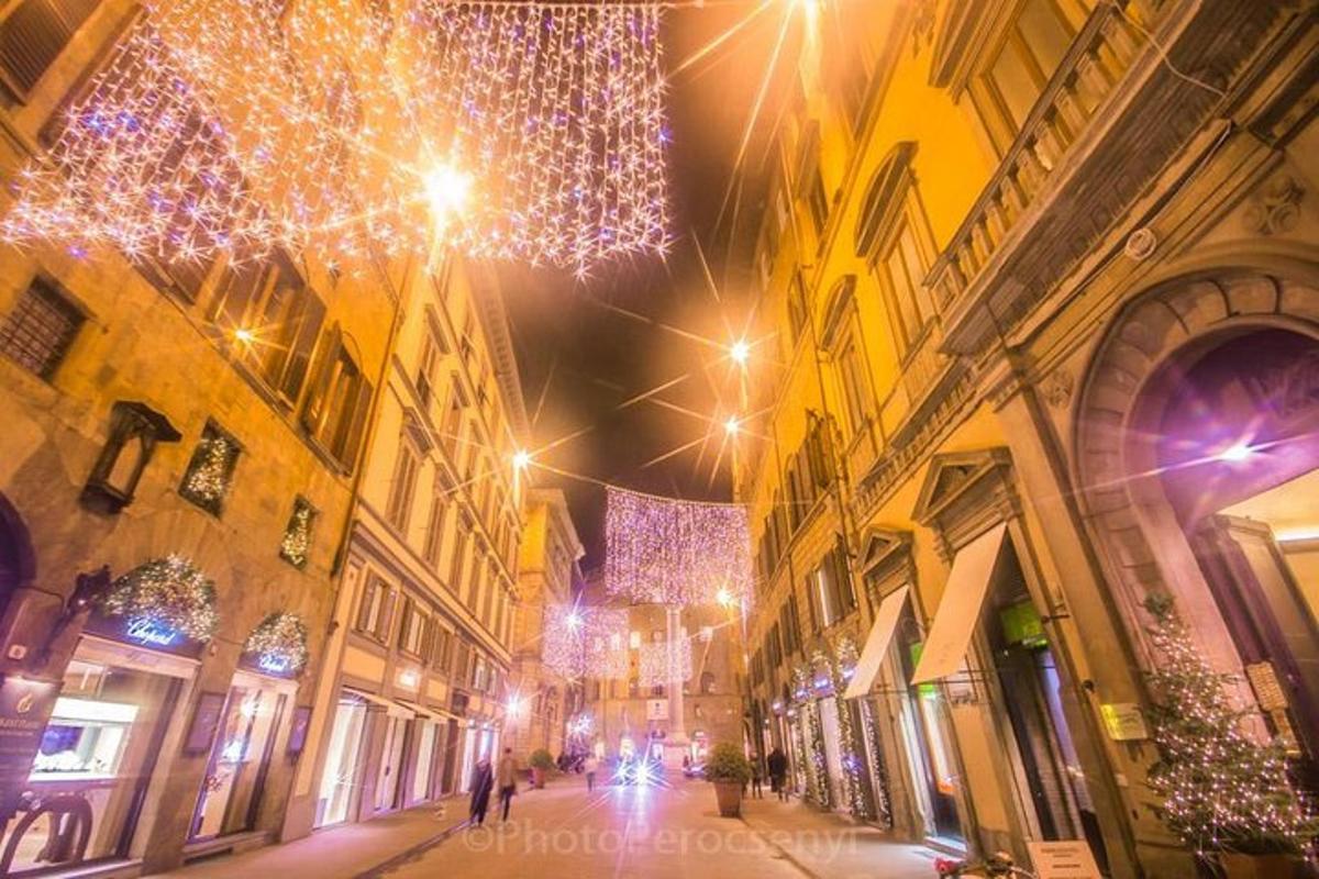 uma rua da cidade à noite com luzes de natal
