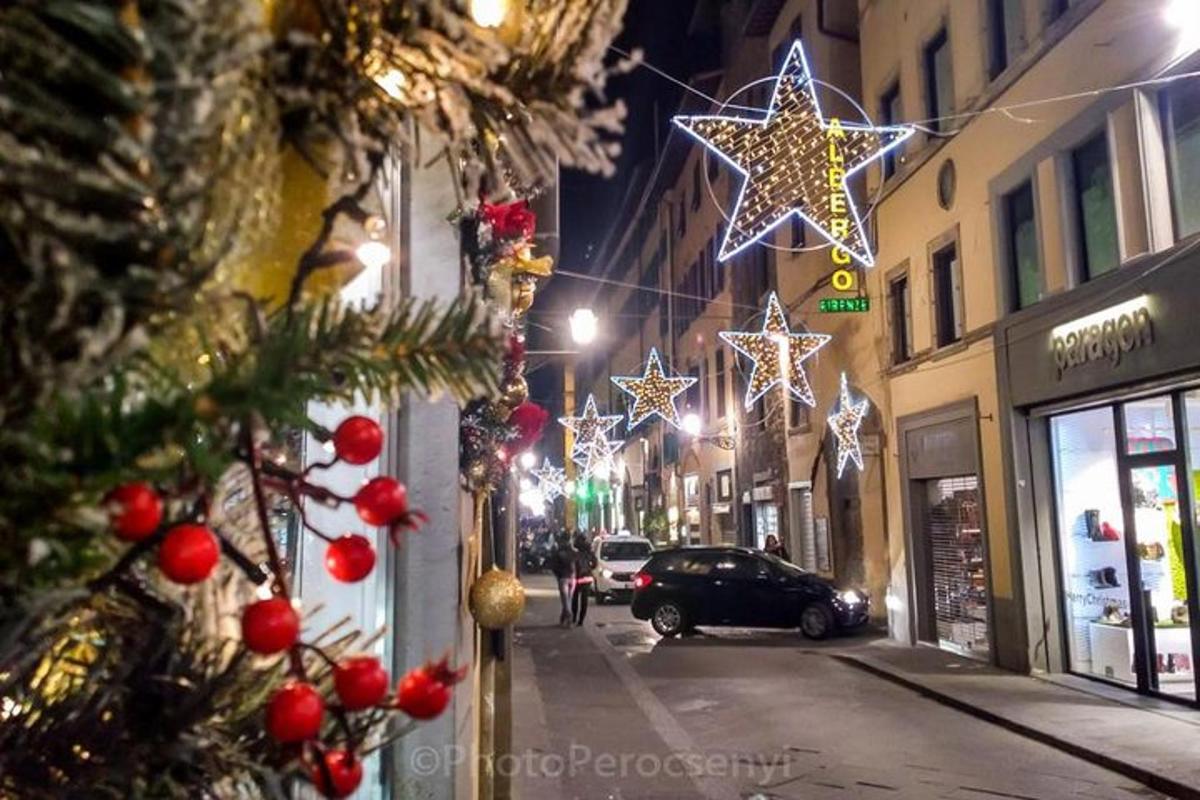 uma rua da cidade com luzes de Natal e uma árvore de Natal