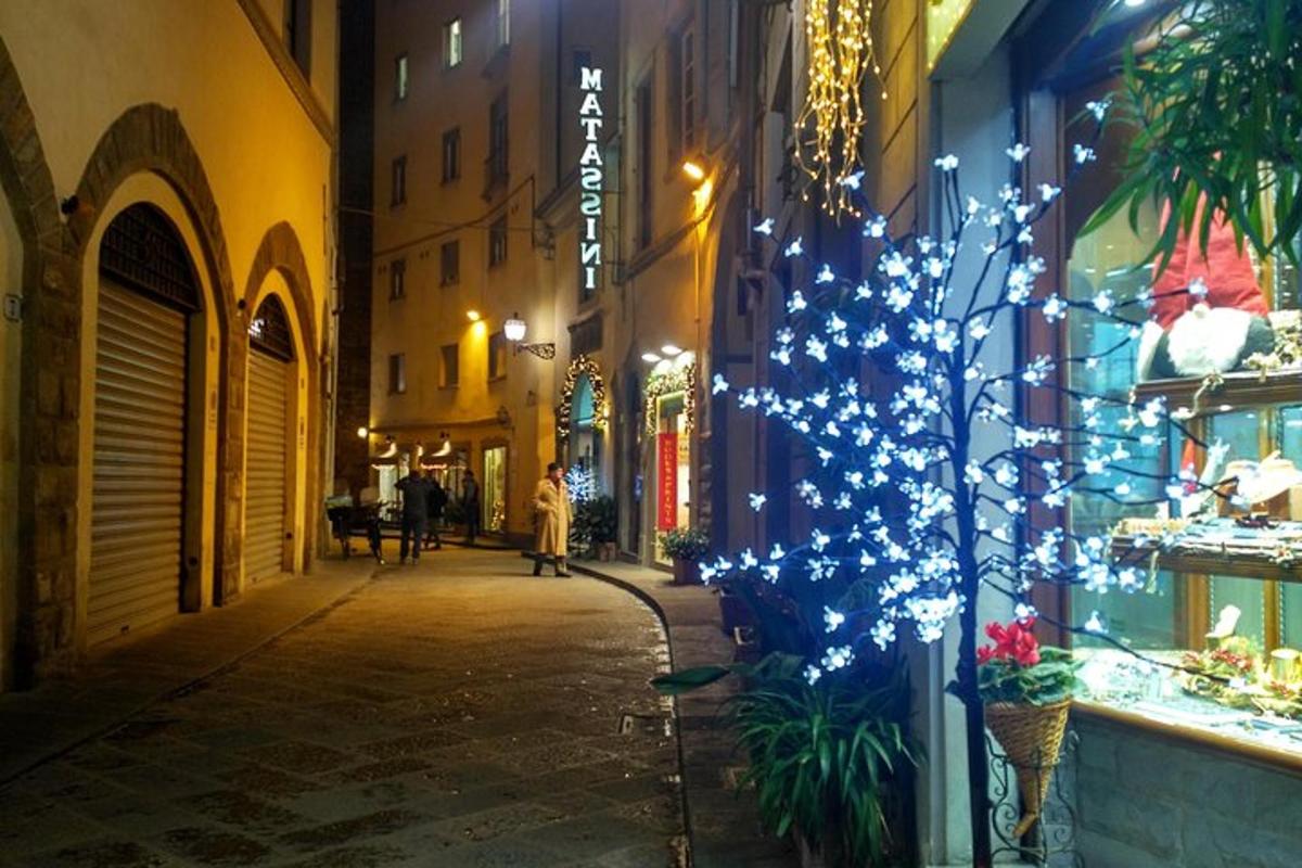 uma rua com uma árvore de natal na lateral de um prédio