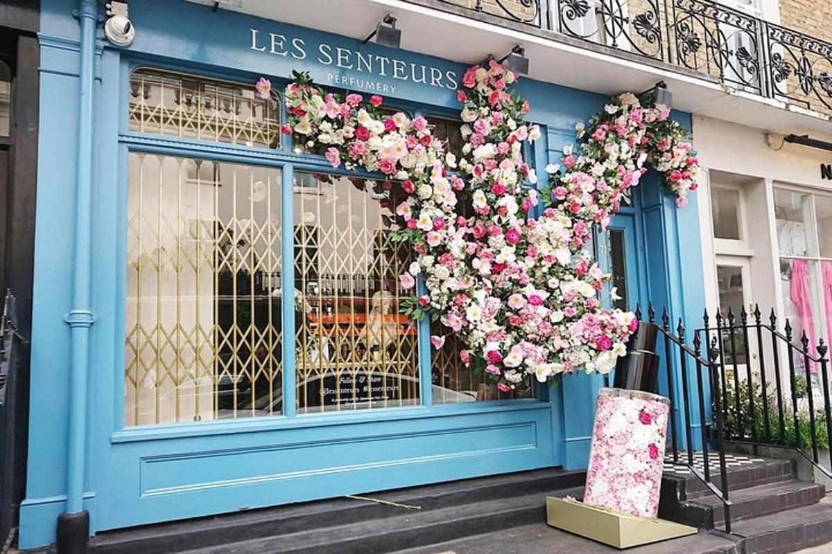 uma fachada de loja com flores rosas na frente