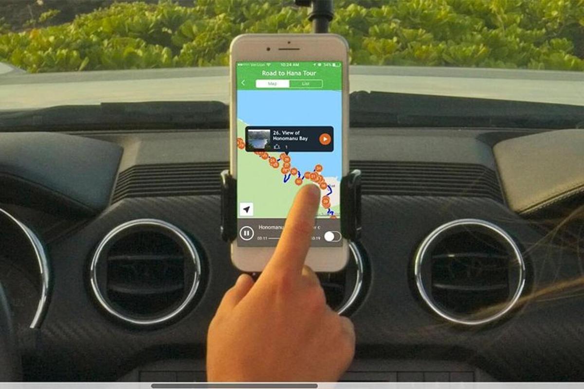 osoba držící mobilní telefon v autě