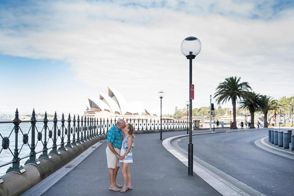 un homme et une femme debout sur un trottoir près d'une rue