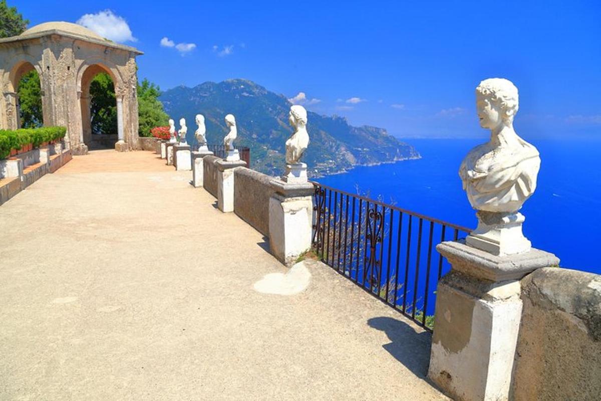 a row of statues on a fence overlooking the ocean