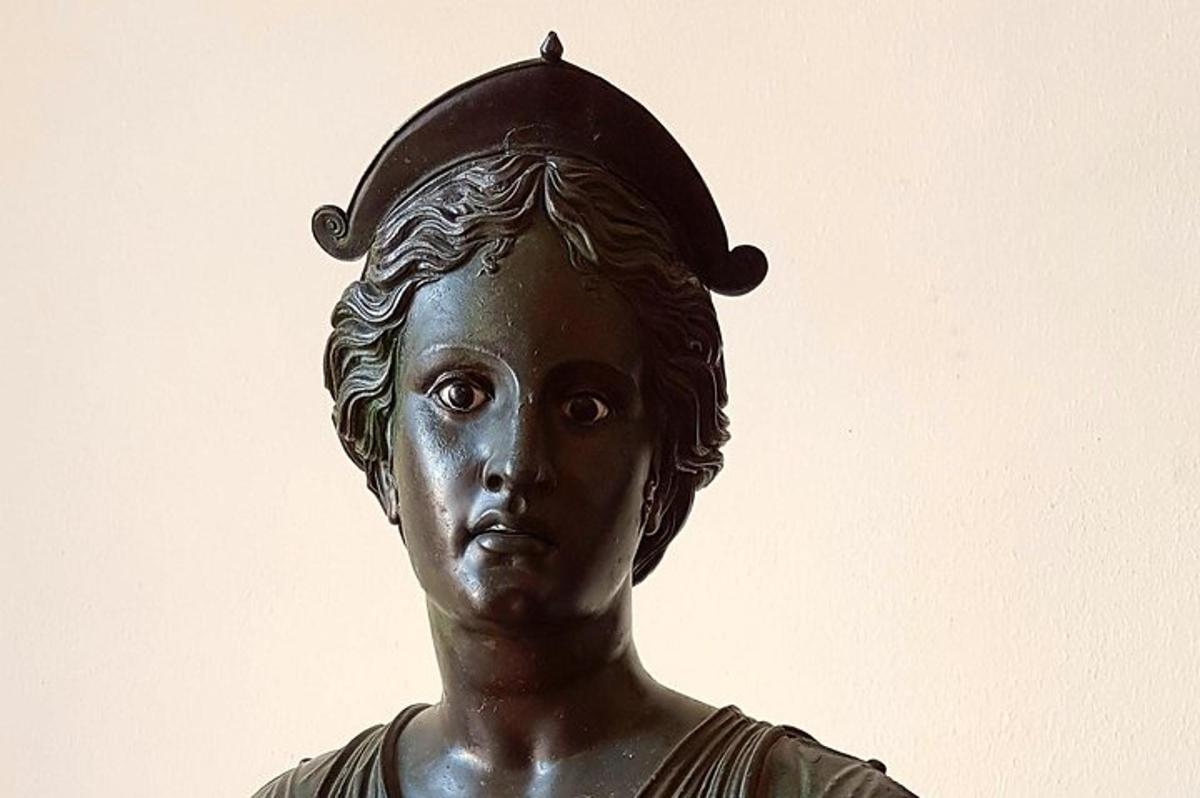 statuja, kurā attēlota sieviete ar cepuri uz galvas