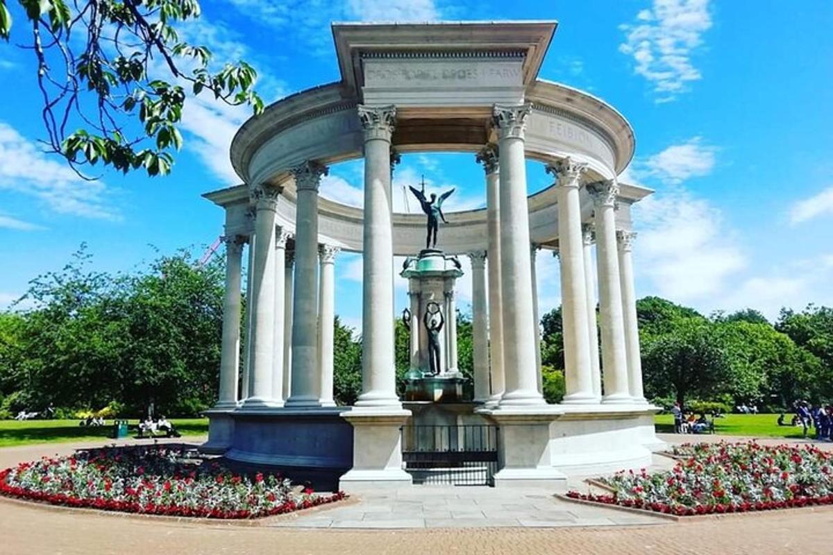 a monument with a statue in a park