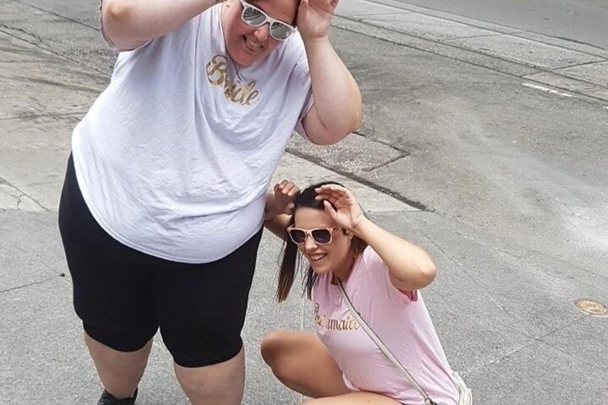 due donne posano per una foto per strada