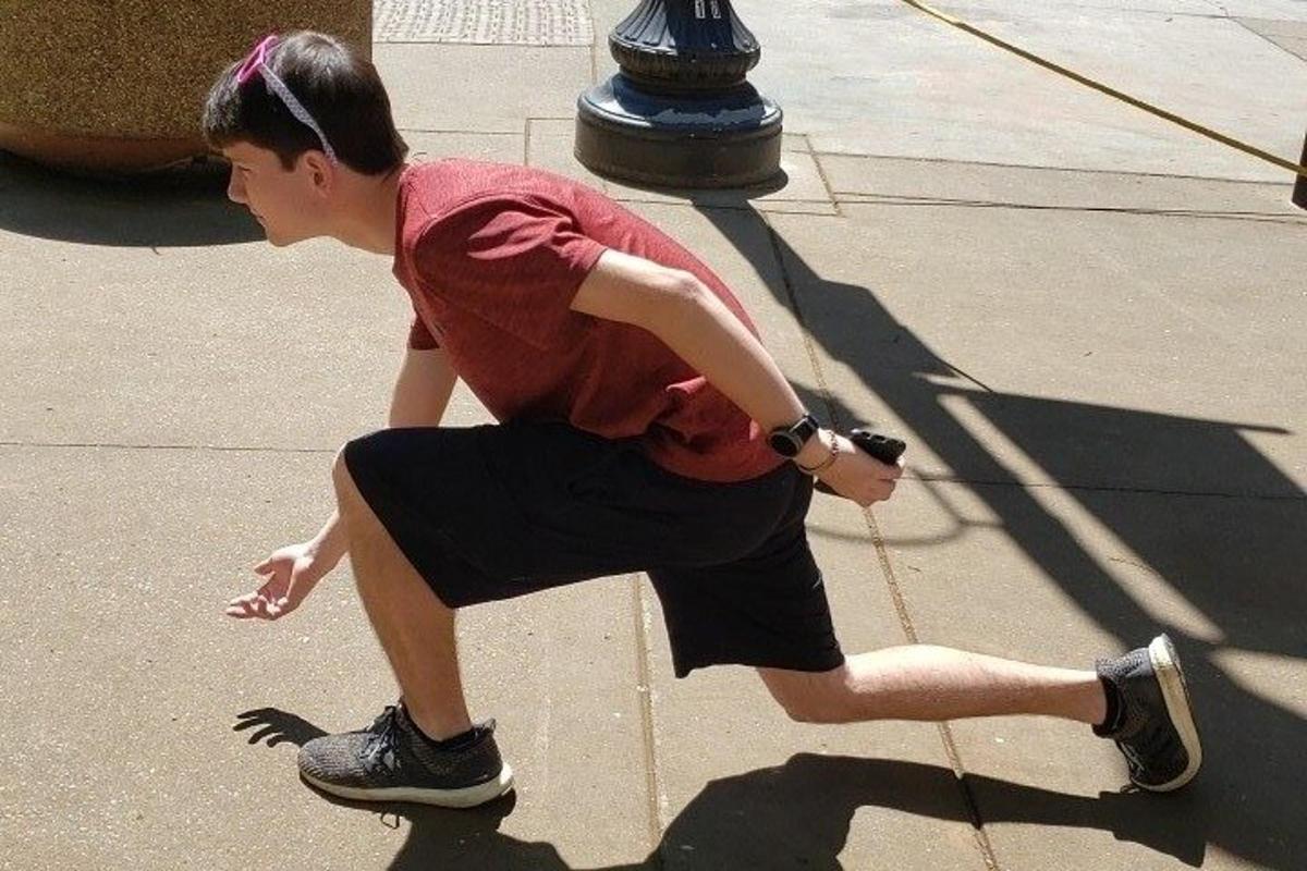 a young man is sitting on a sidewalk