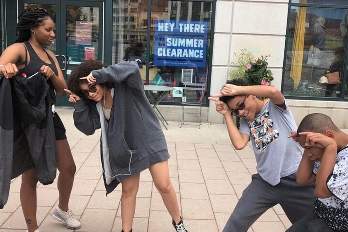 a group of people standing on a sidewalk looking at their cell phones