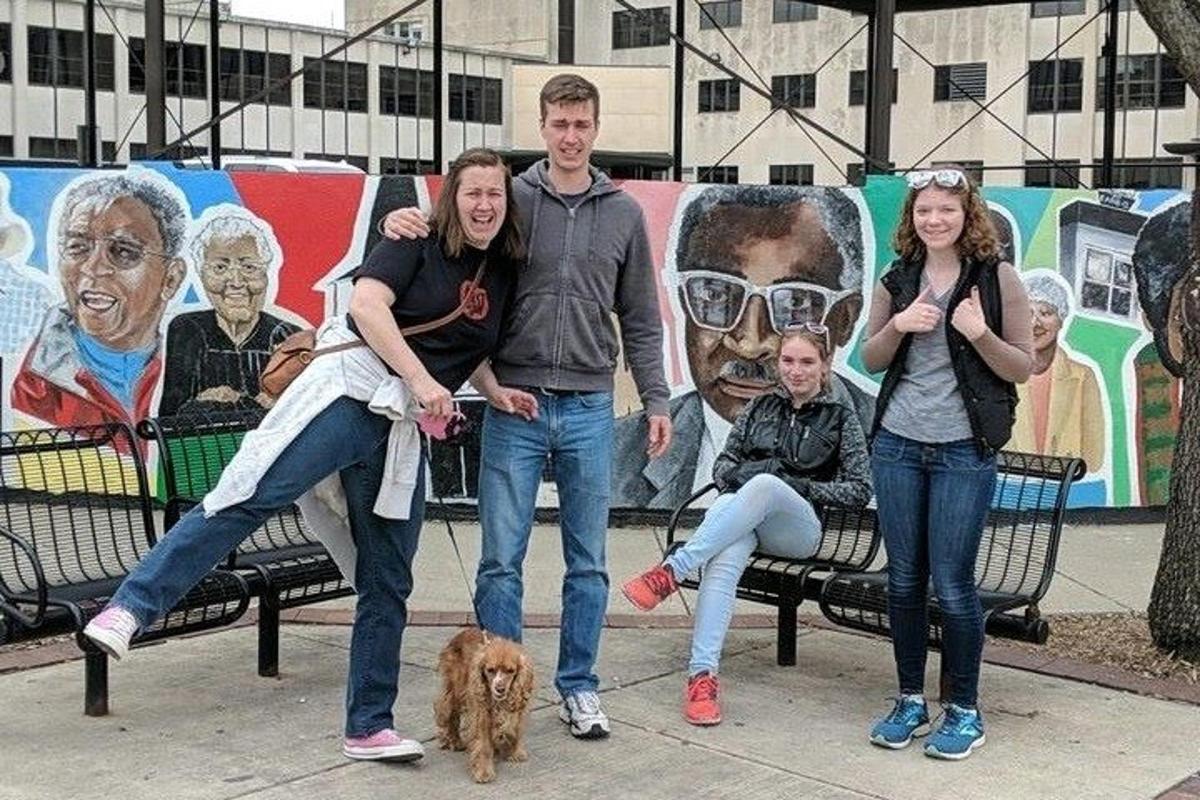 a group of people standing on a bench with a dog