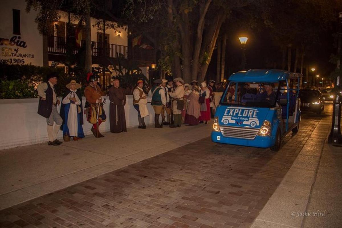 sekelompok orang berdiri di trotoar dekat bus