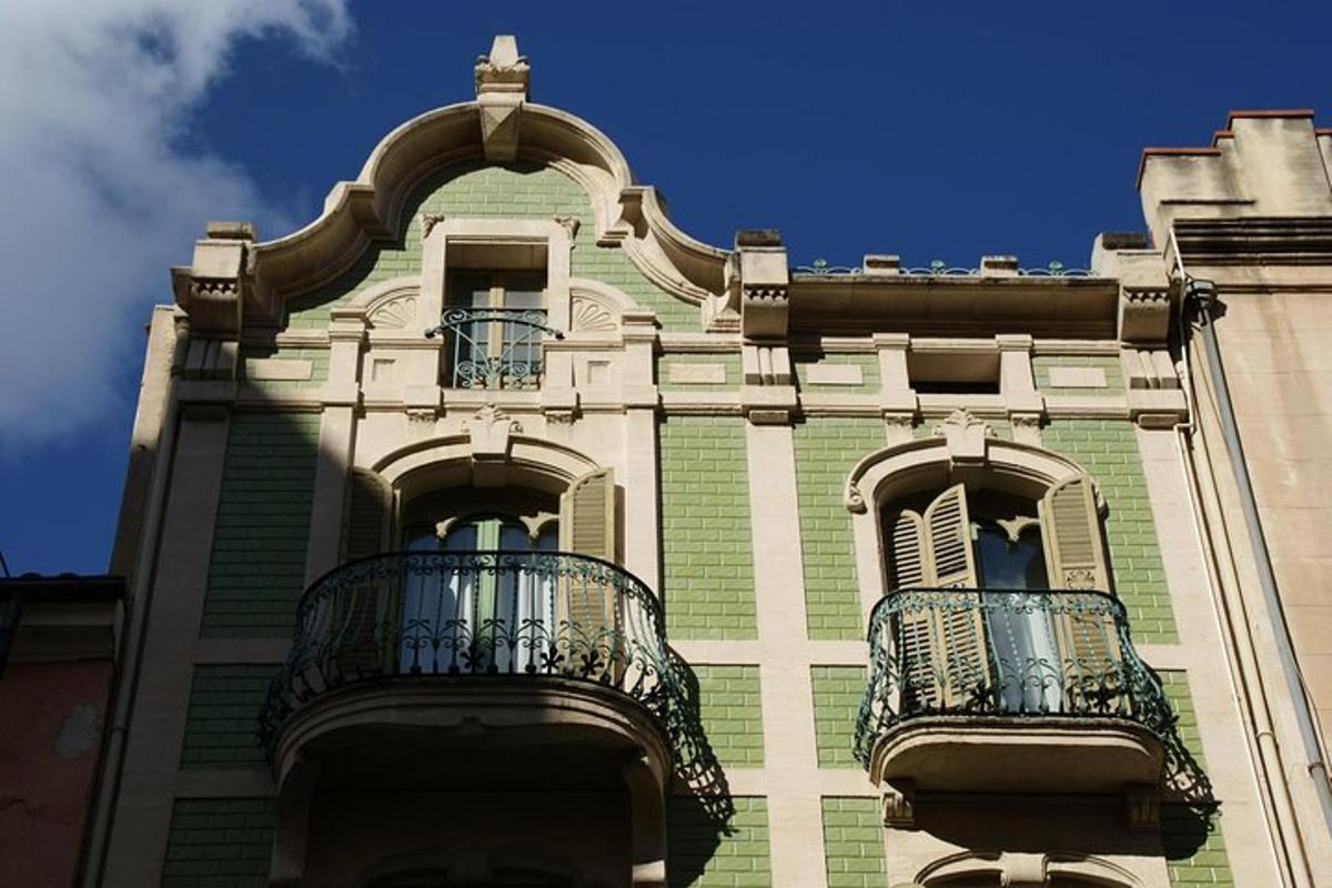 Un edificio con dos balcones a los lados.
