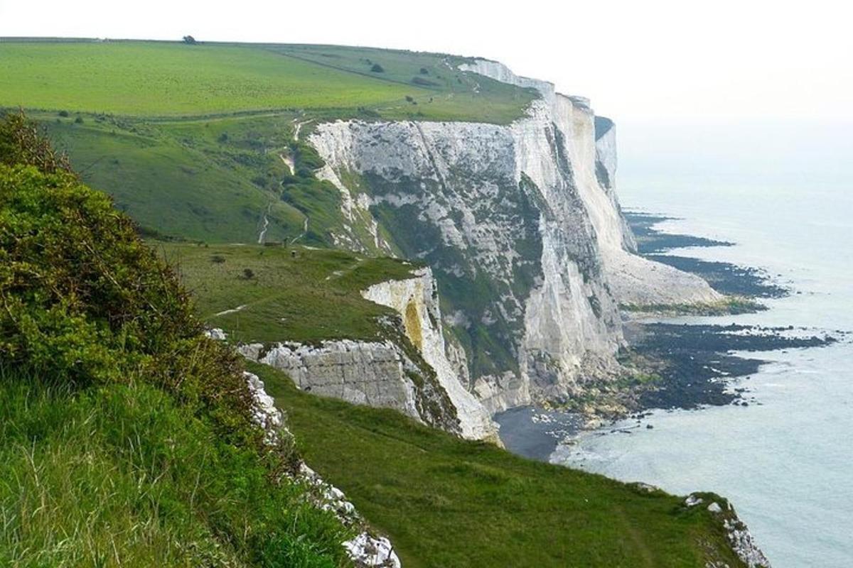 a large white cliff next to the ocean