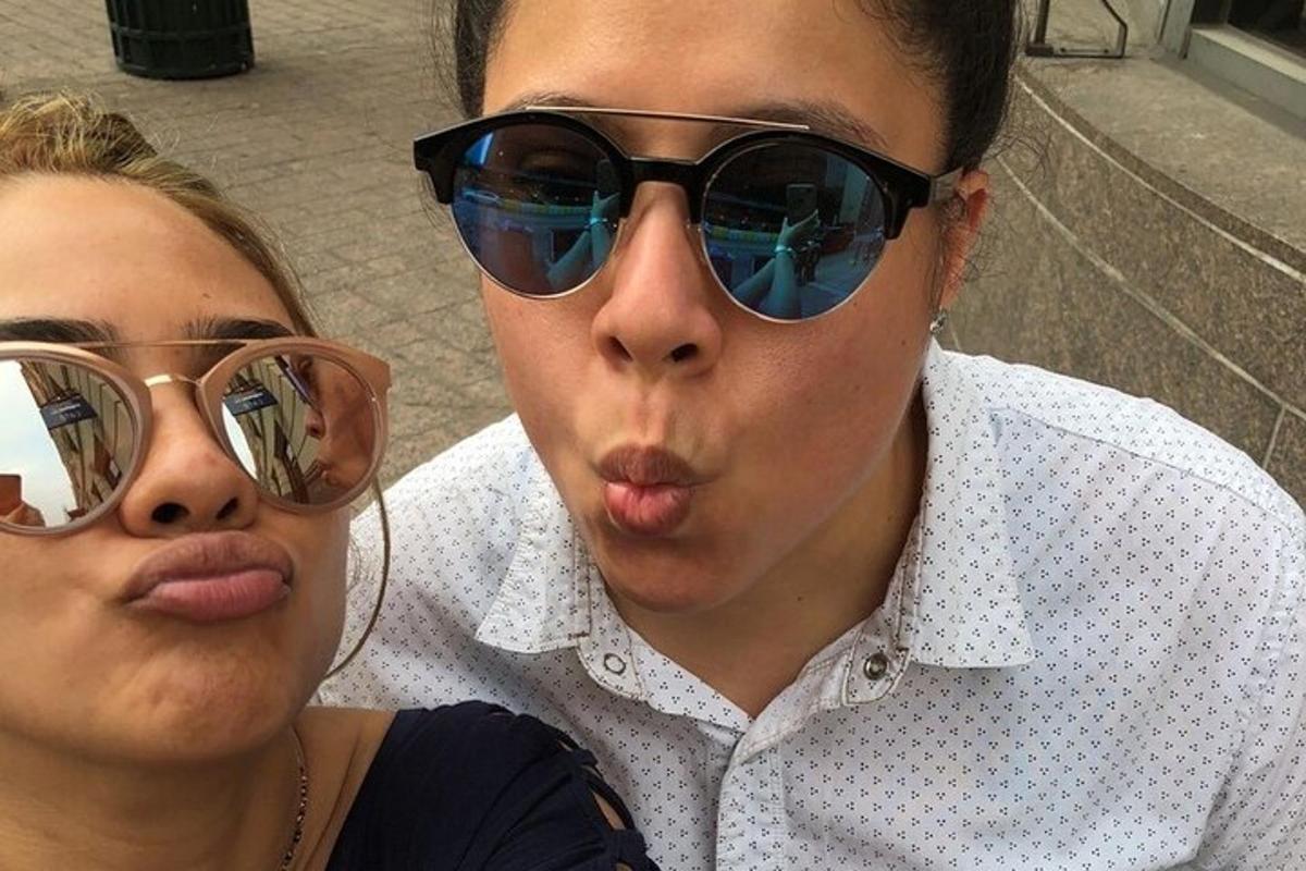 un uomo e una donna che indossano occhiali da sole e si tirano la lingua
