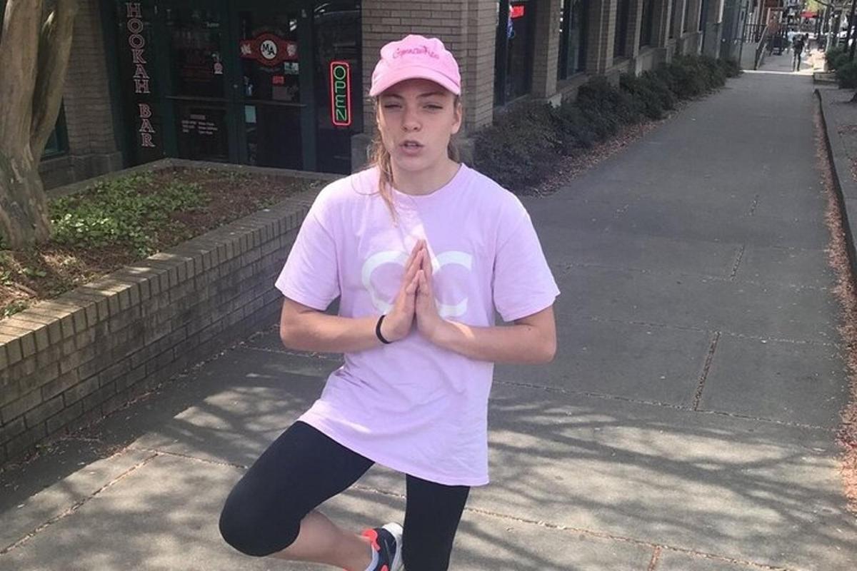 a young woman in a pink hat is doing yoga