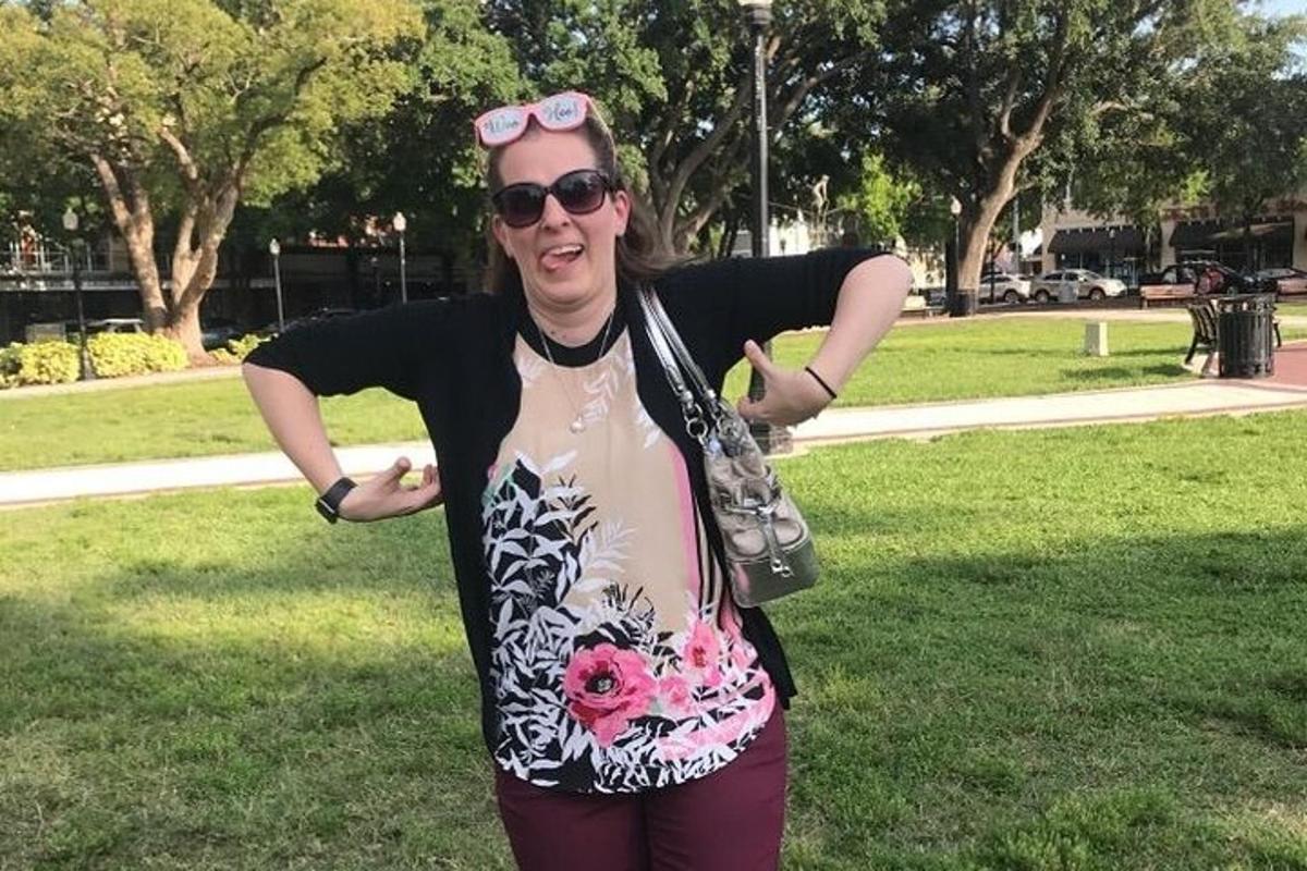 una donna in piedi in un parco con le braccia tese
