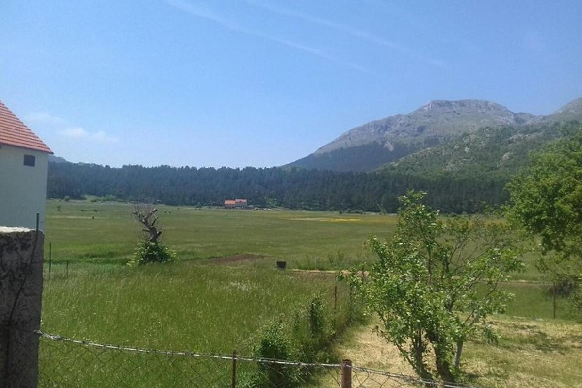 un câmp cu gard și munți în fundal