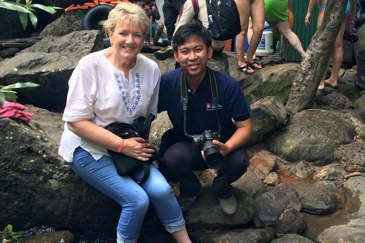 o femeie așezată lângă un bărbat cu un aparat foto