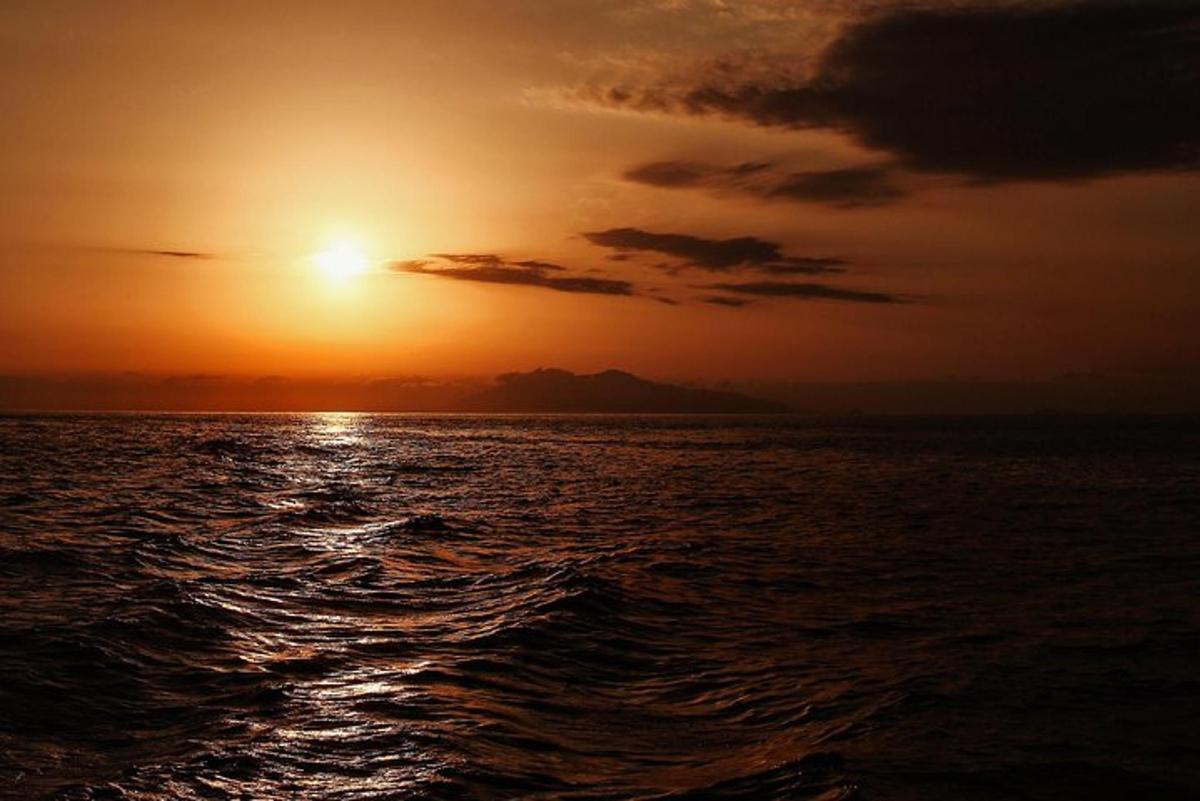 um pôr do sol sobre o oceano com o sol se pondo