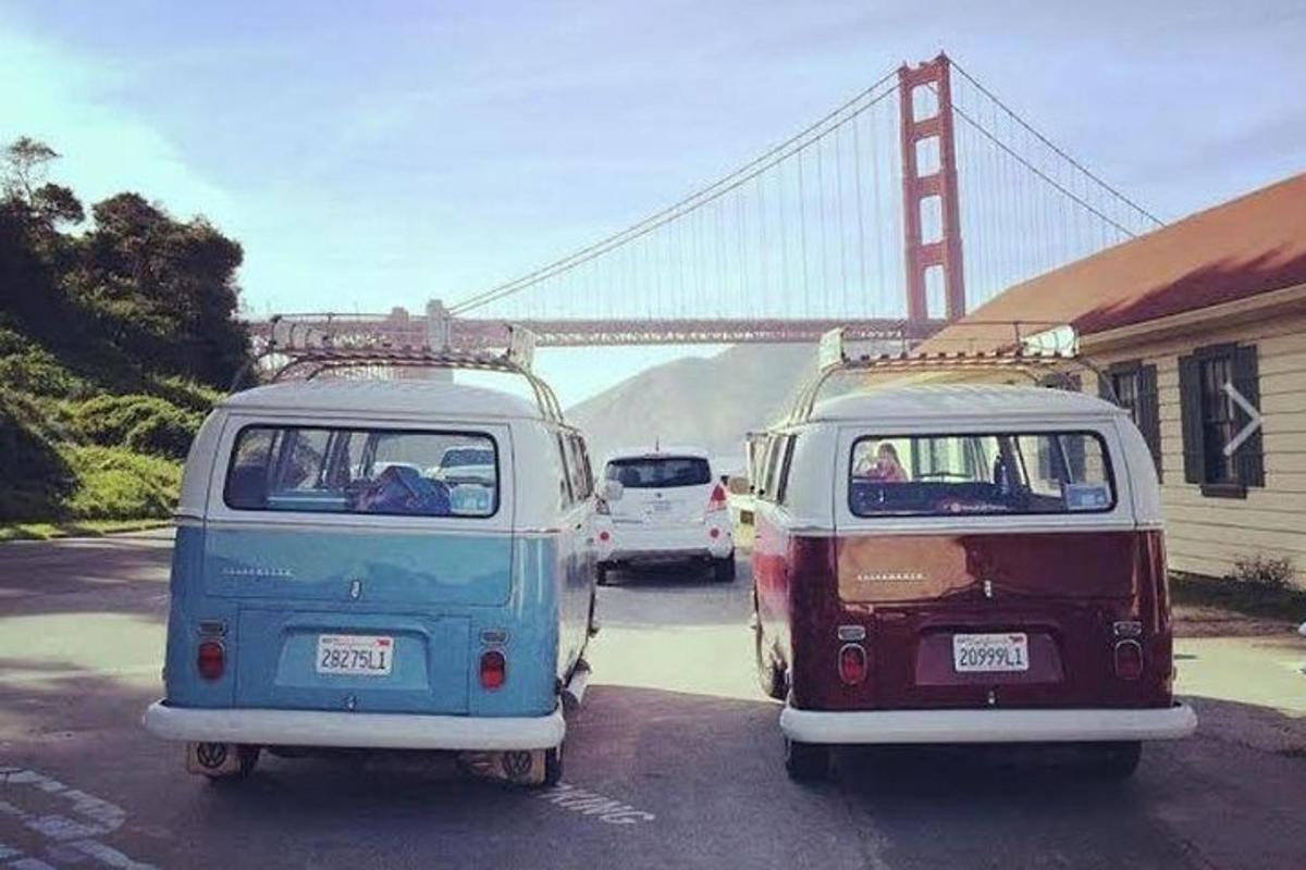 dois ônibus vw estacionados em frente à ponte golden gate