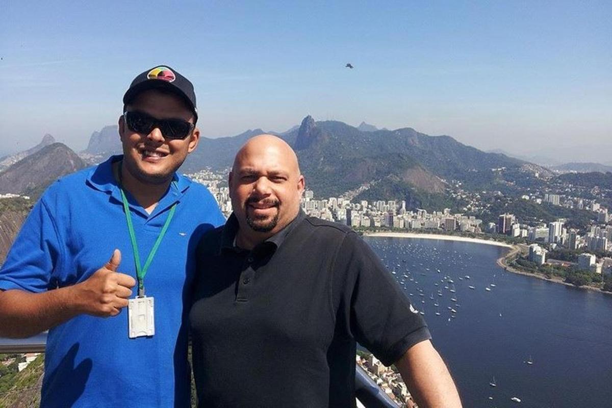 two men posing for a picture on top of a mountain