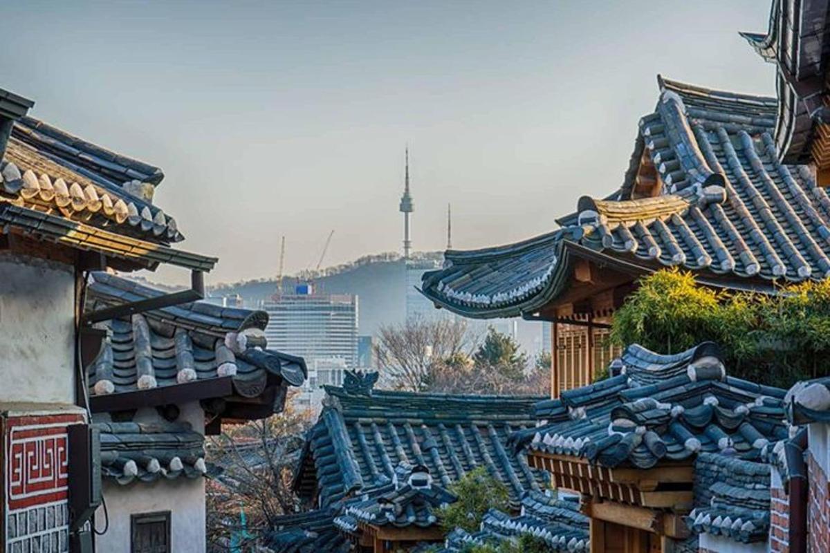 a group of roofs of buildings with a river in the background