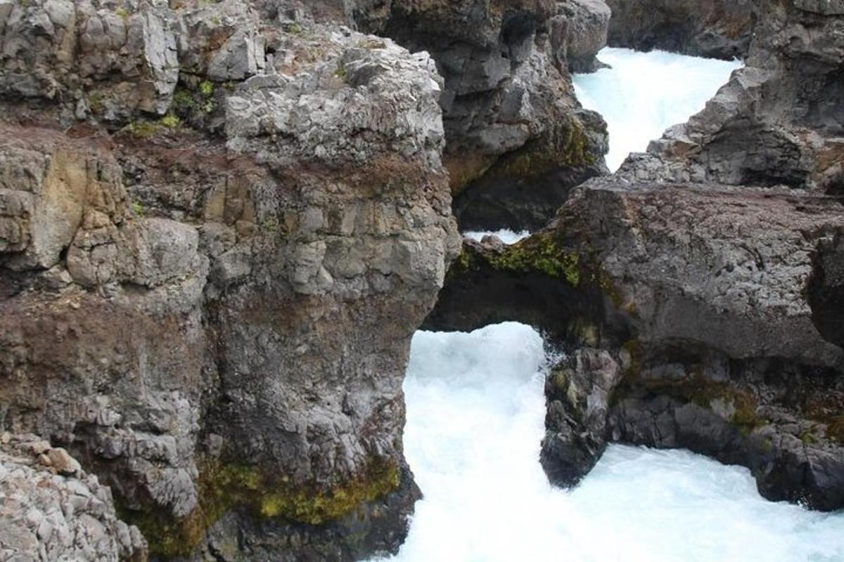 un fiume con la neve sul fianco di una montagna