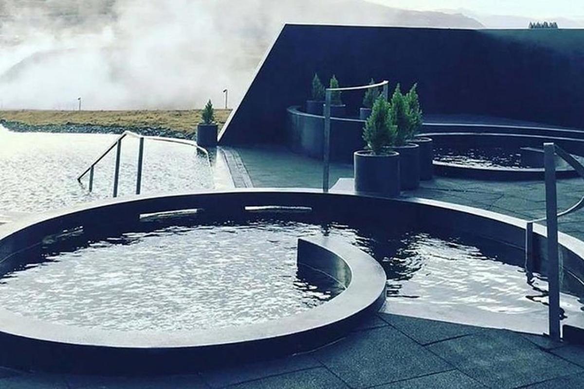 una grande piscina circolare d'acqua di fronte a un edificio