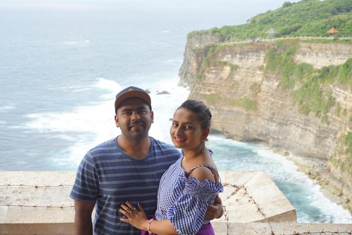 a man and a woman standing next to the ocean