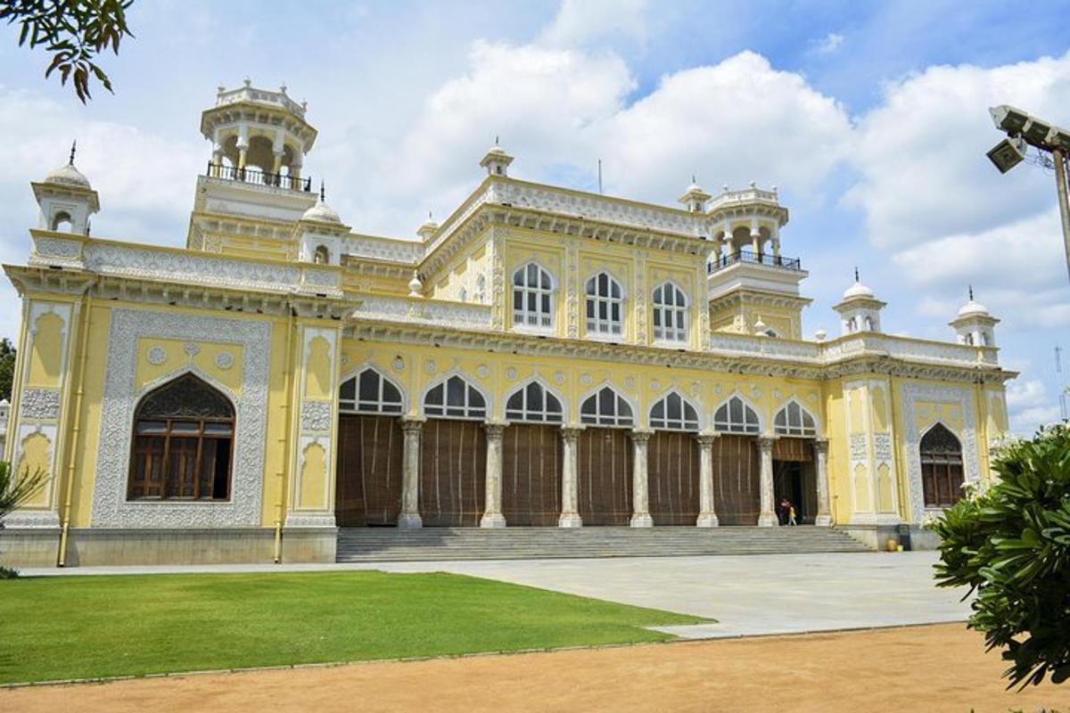 a large yellow and white building with a grass yard