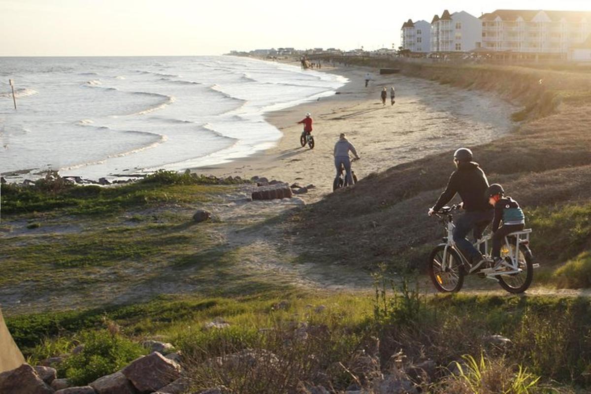 a group of people riding bikes on the beach