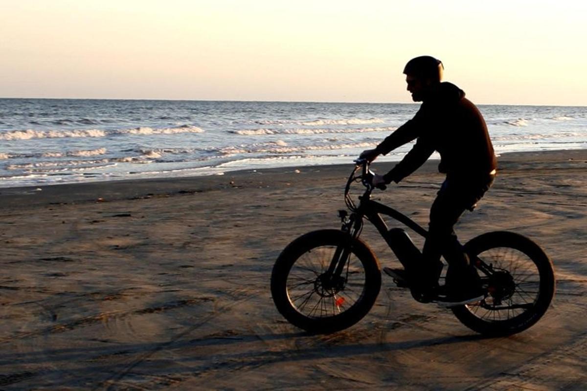 a man riding a bike on the beach