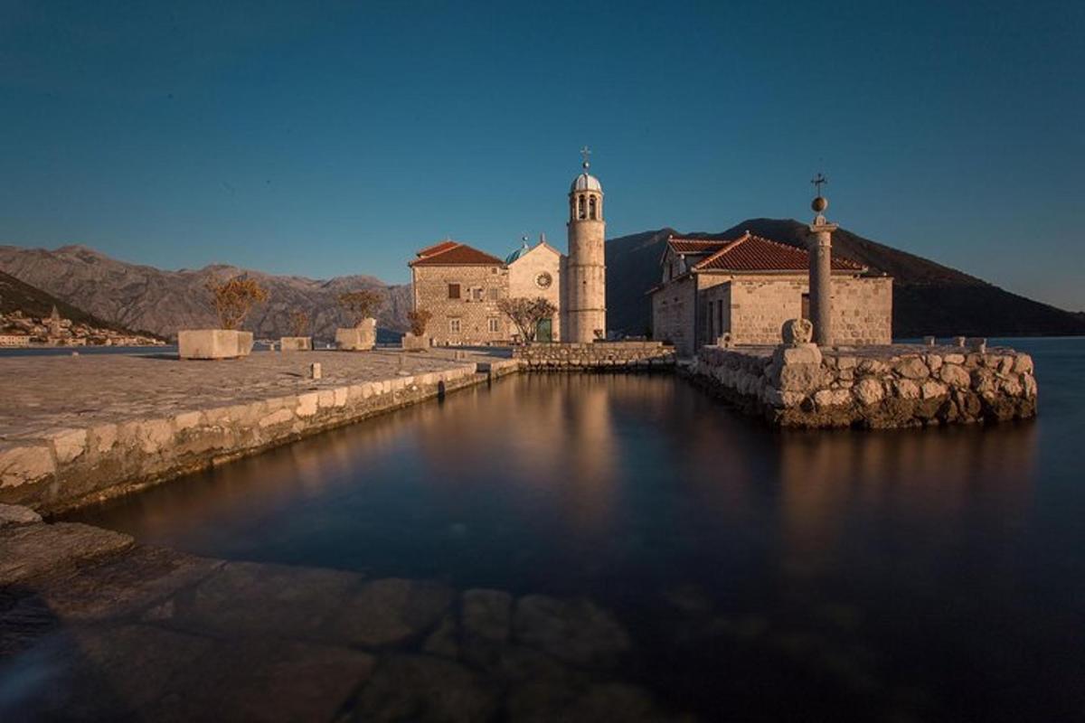 un edificio con una torre dell'orologio accanto a uno specchio d'acqua