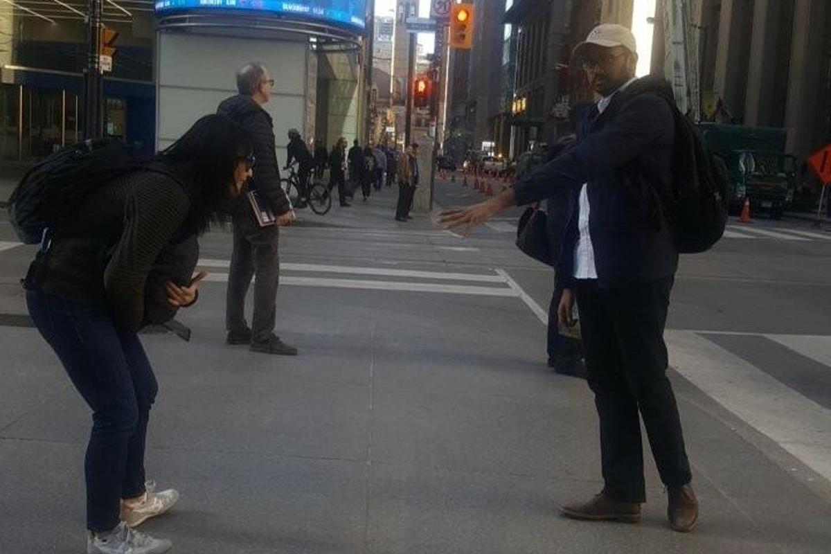 a woman pointing at a man on a city street