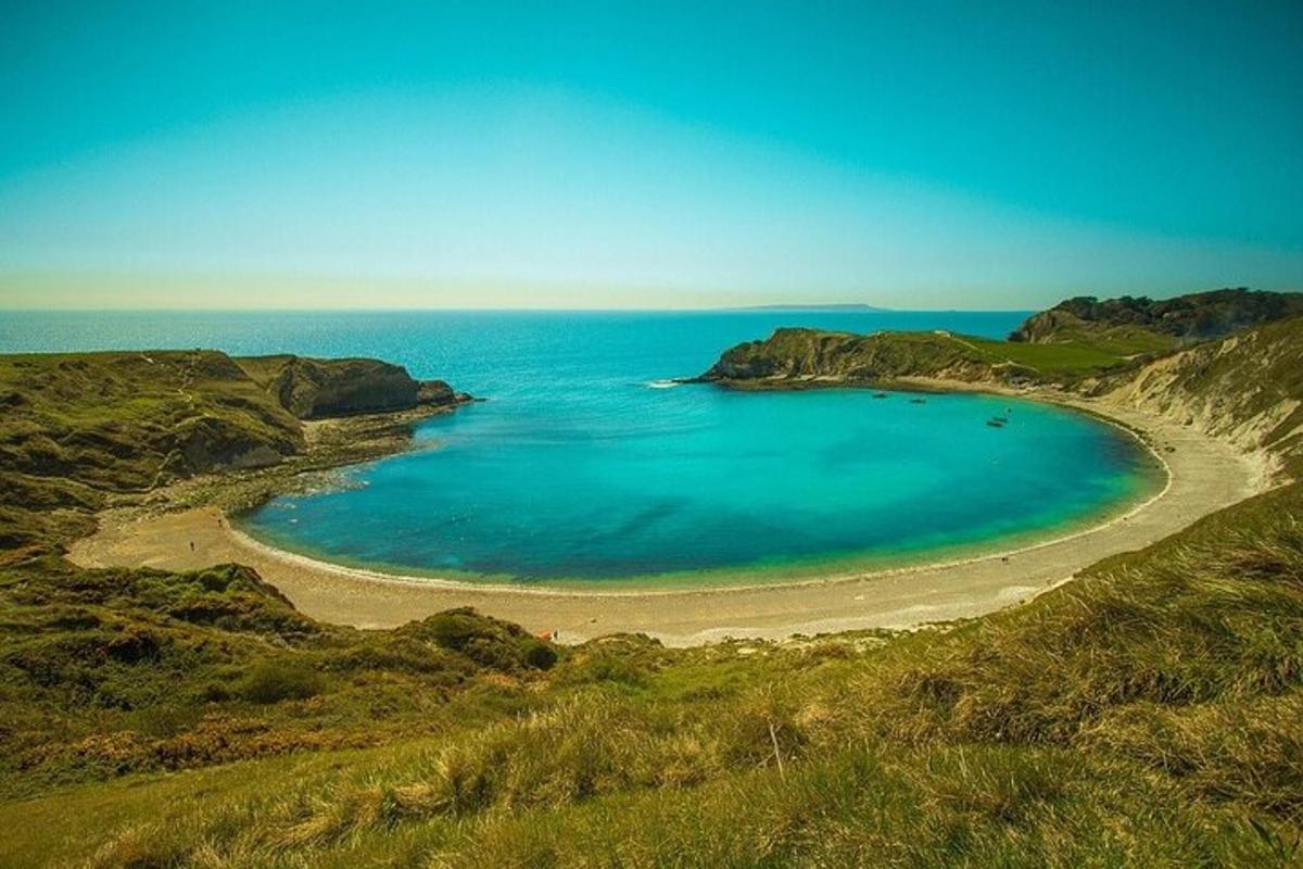 plaża na zboczu wzgórza z błękitną wodą
