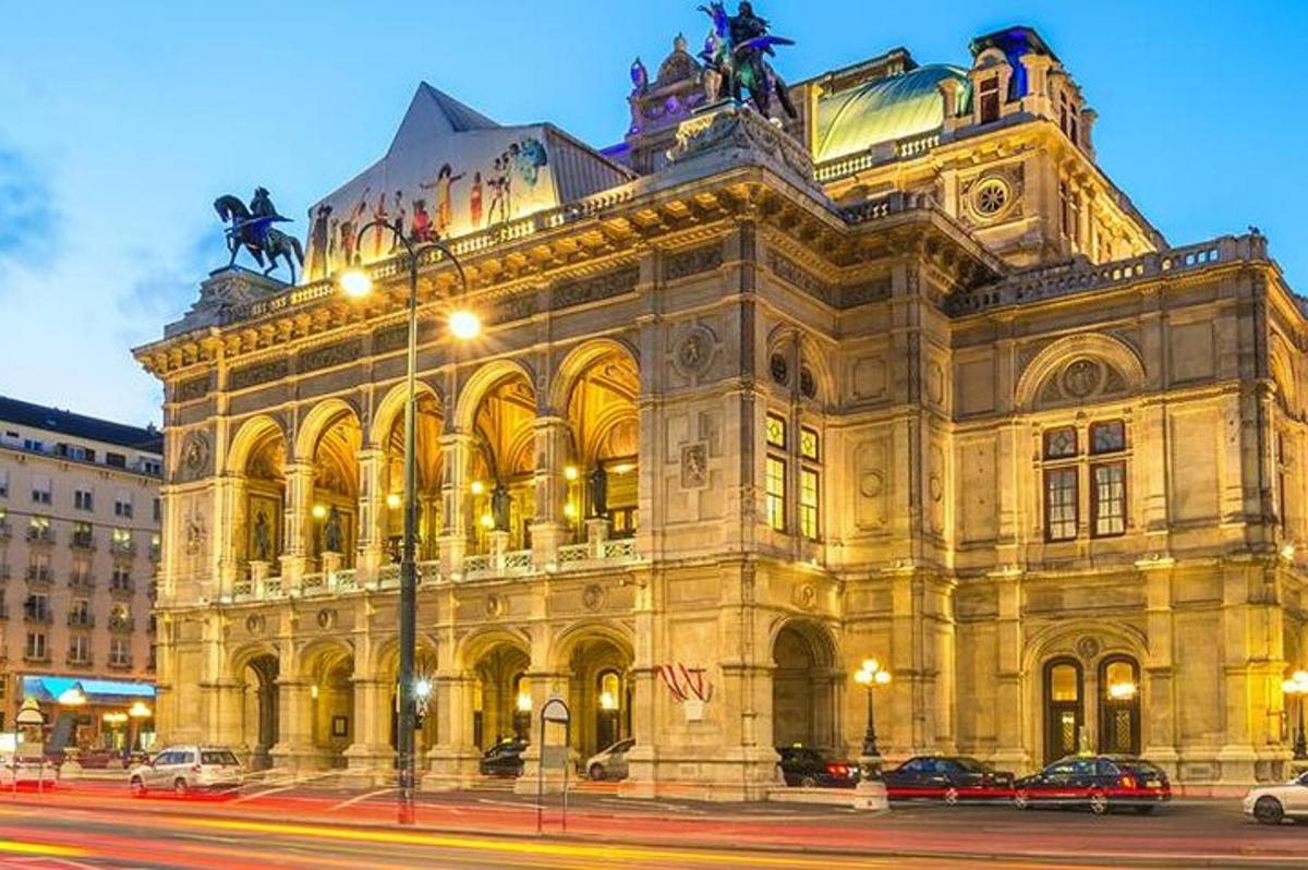 un grande edificio con auto parcheggiate di fronte