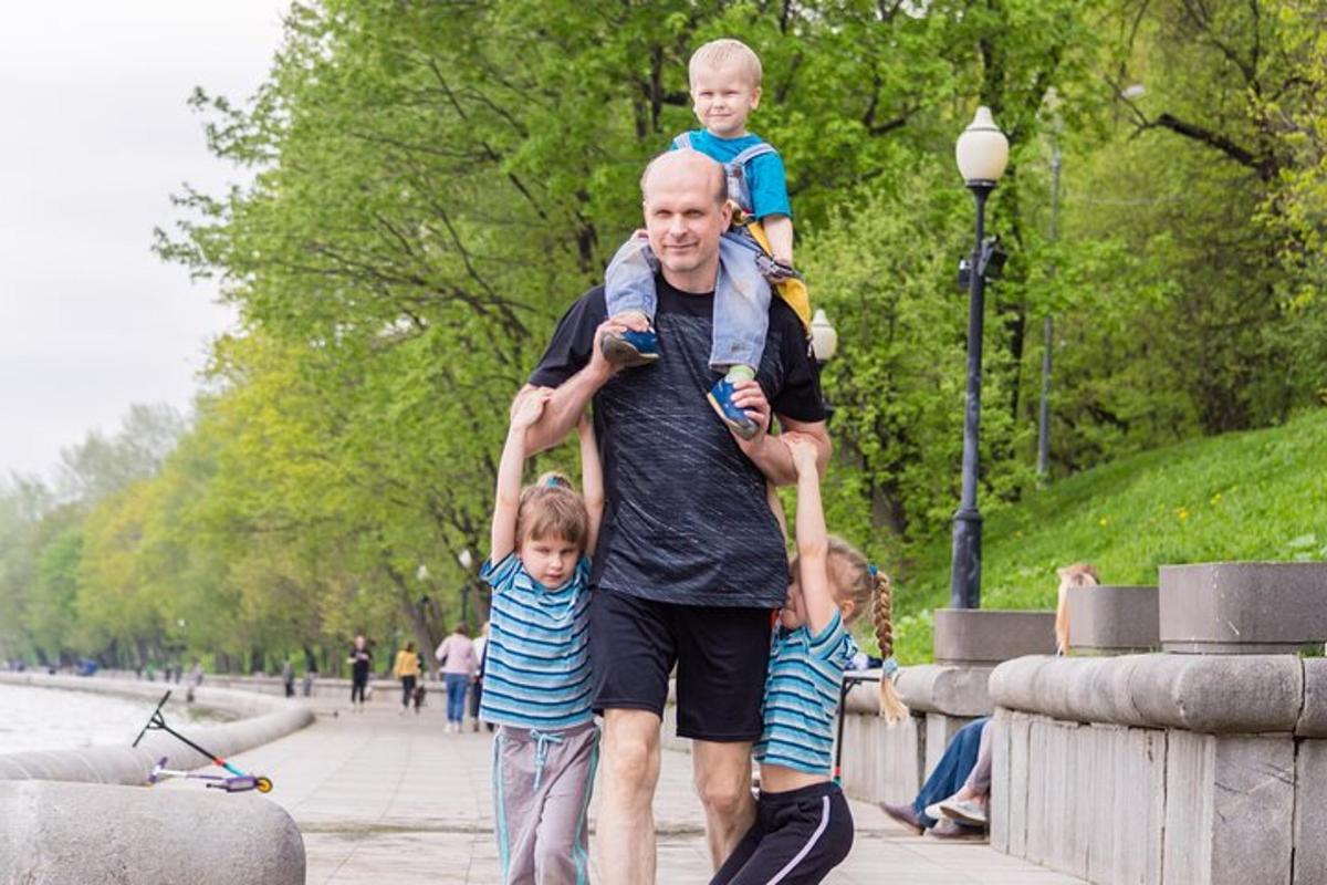 Un hombre que lleva a dos niños pequeños sobre sus hombros