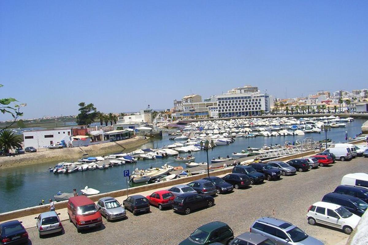 un parcheggio con auto parcheggiate accanto a un porto turistico