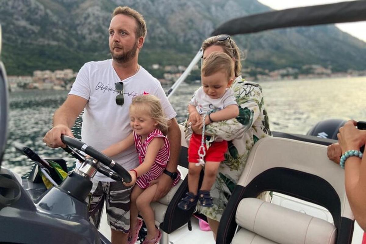 een man en twee kinderen zitten op een boot